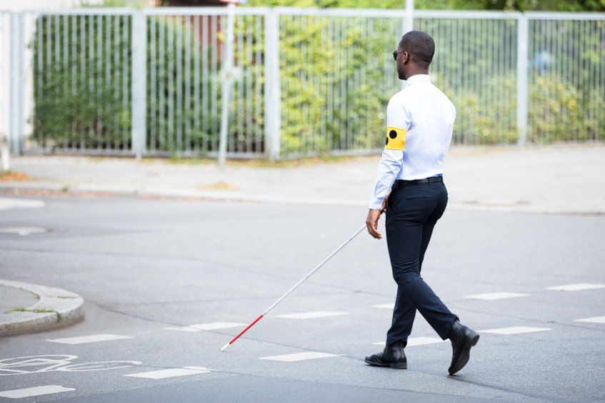 Blind Man Wearing Armband Walking With Stick